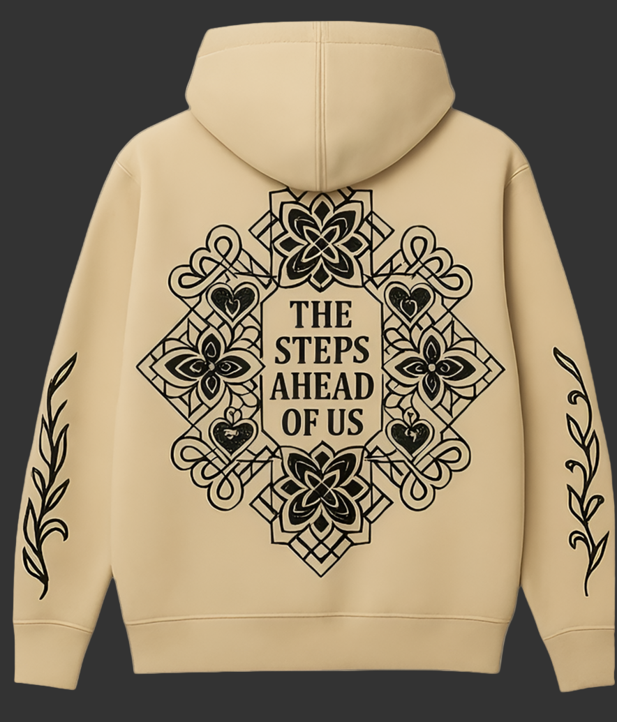 Beige hoodie with black geometric design and text on the back against a dark gray background.